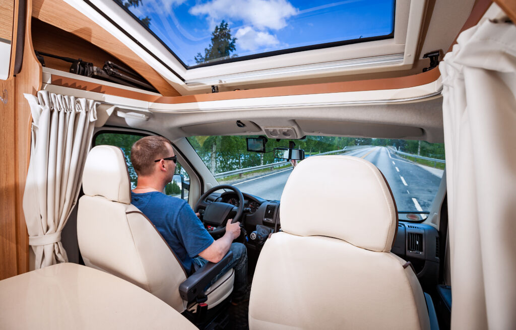 Rear view of a man driving an RV on a road trip
